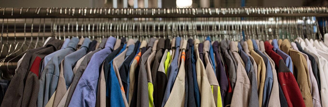 A kaleidoscope of work shirts hygienically cleaned by UniFirst are on hangers being prepared to go through sortation and prepared for delivery to customers.