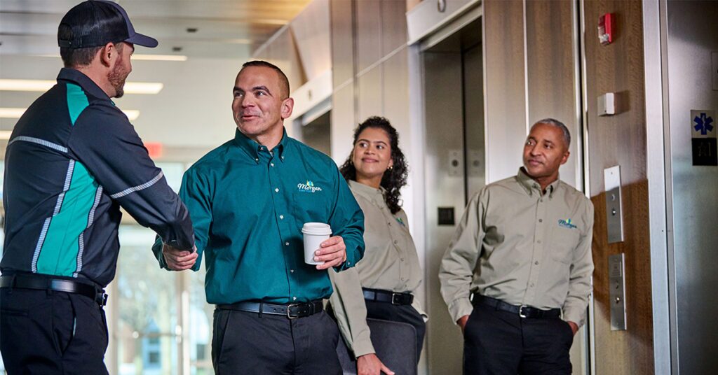 UniFirst representative shaking hands with uniform rental service customer