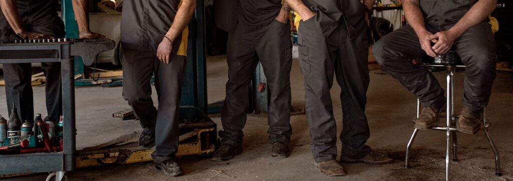 A group of automotive industry workers wearing UniFirst cargo pants.