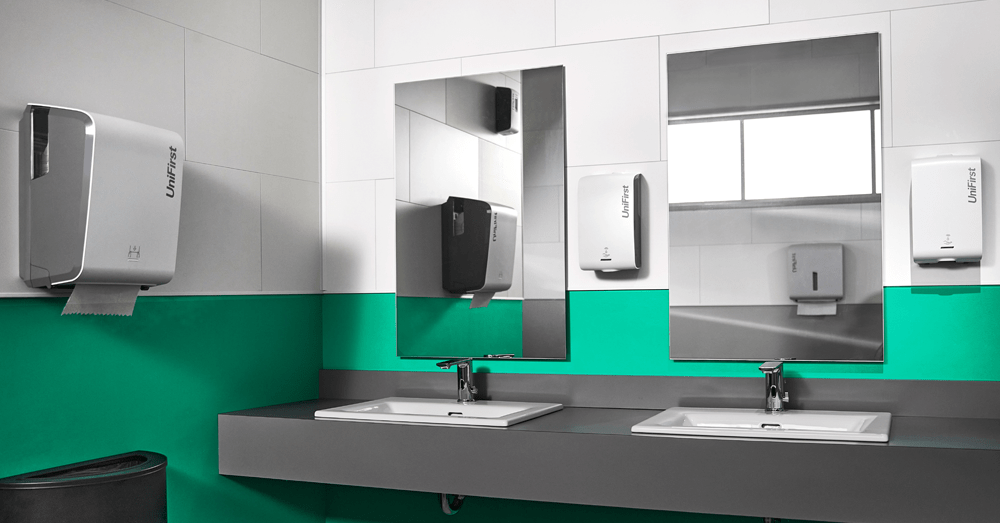 A commercial restroom featuring UniFirst's Essential Series of restroom dispensers