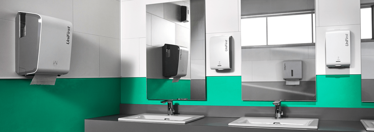 A commercial restroom featuring UniFirst's Essential Series of restroom dispensers
