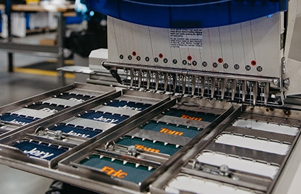 A UniFirst custom emblem machine creating emblems for a uniform rental program