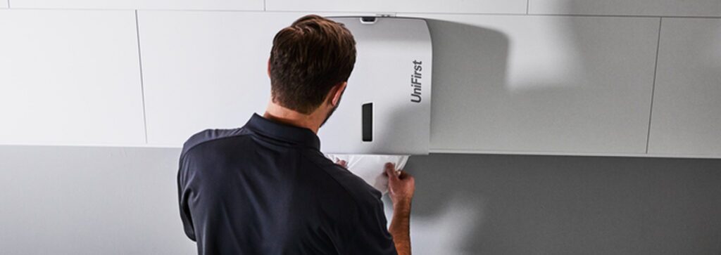 A man using a multifold bathroom paper towel dispenser